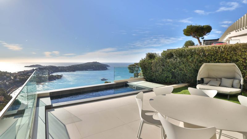 Terrasse de luxe avec jacuzzi privé et piscine à débordement offrant une vue panoramique sur la mer Méditerranée, sur la Côte d’Azur. Espace détente moderne avec mobilier design.